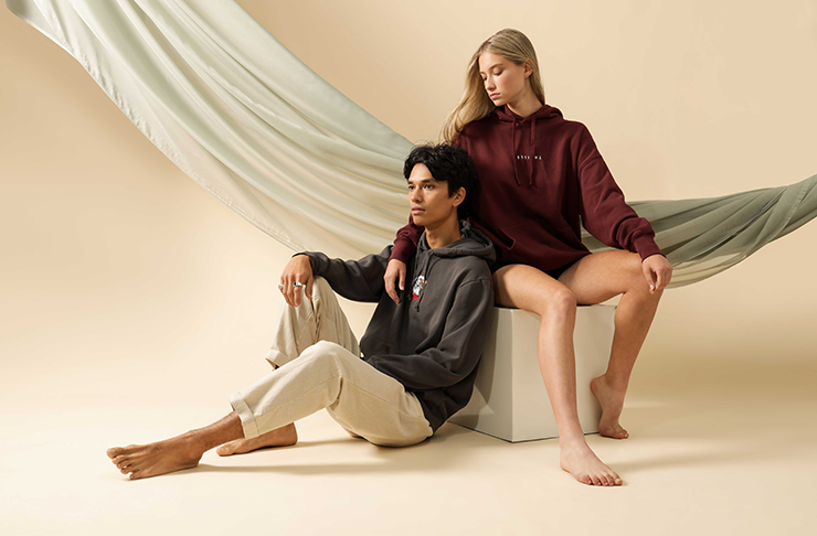Two models sitting in sustainable clothing.